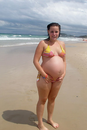 Topless pregnant women on sunny beach
