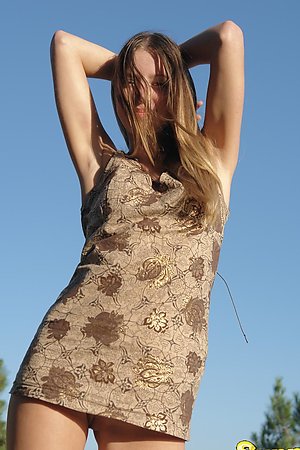 Sexy teen girl getting out of her clothes and posing nude in the sun